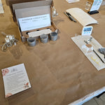 Handmade candle making kit on a brown table with materials and instructions.