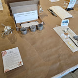 Handmade candle making kit on a brown table with materials and instructions.