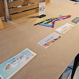 Table with printed materials and stationery items in a workshop setting